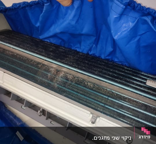 מזגן עם כיסוי כחול בתהליך ניקוי